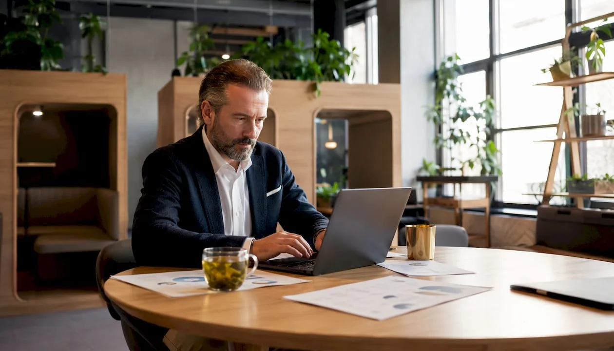 Ein Hotelmanager überprüft am Laptop die aktuellen Gästebewertungen.
