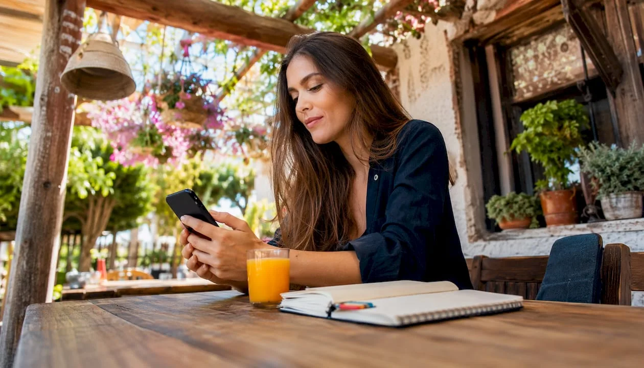Eine Frau verwaltet ihren Channel Manager bequem über das Smartphone.